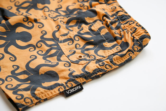 Close-up of quick-dry recycled polyester fabric – octopus desert sand swim trunks
