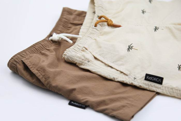Close-up of quick-dry recycled nylon fabric – palm almond swim trunks