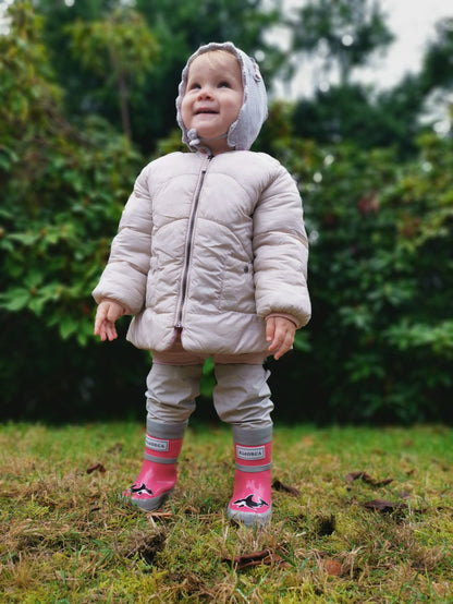 Child wearing pink above-knee rain waders