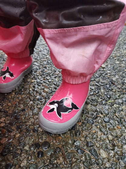 Child splashing in pink rain boots with above-knee waders by KidORCA