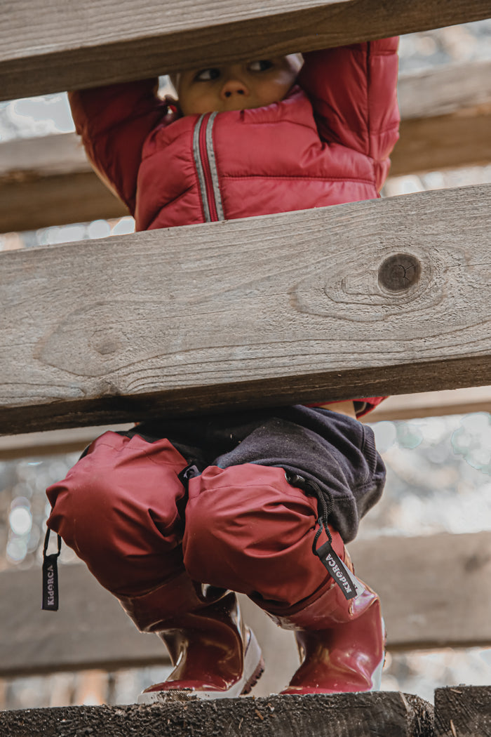 Child wearing merlot above-knee rain waders – side view