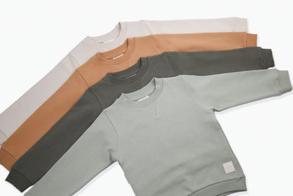 Close-up of french terry fabric and crewneck on oat kids sweatshirt