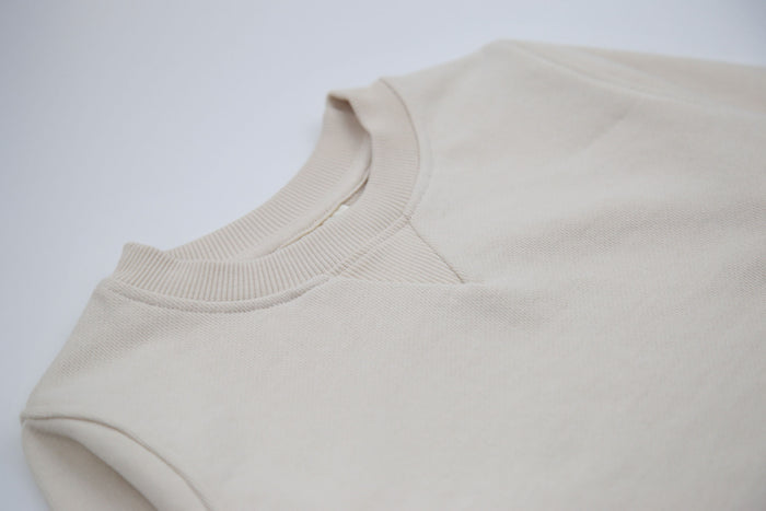 Close-up of french terry fabric and crewneck on oat kids sweatshirt