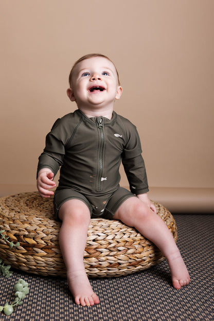 Baby playing in Trout Kalamata swim jumpsuit by KidORCA