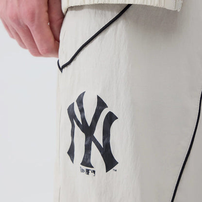 The model is wearing these MLB Piping Track New York Yankees Track Pants in cream. 4