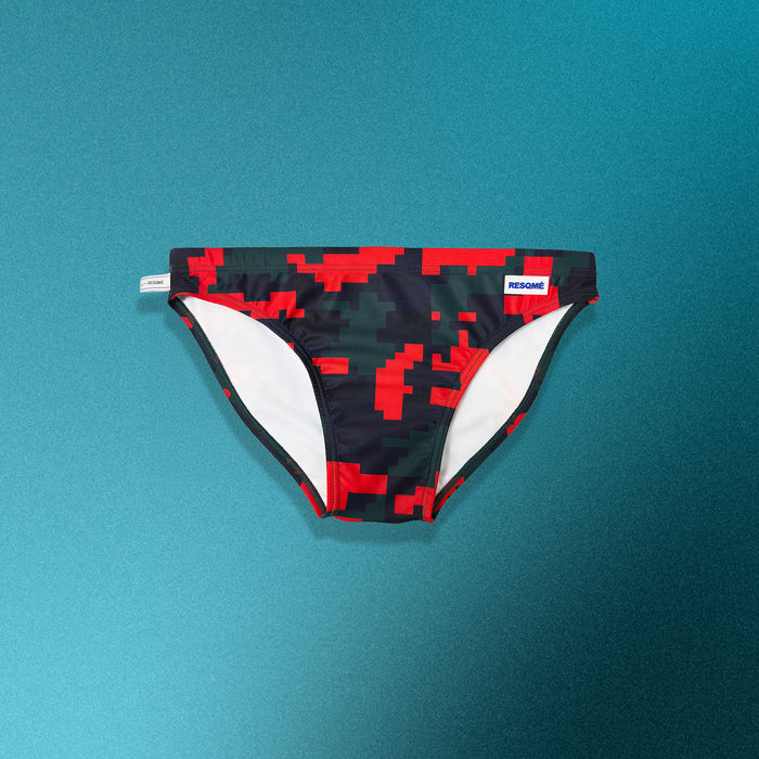 Black and red pixelated swim briefs on a teal background