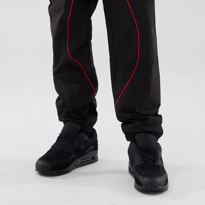 The model is wearing these Red Bull Racing Piping Track Pants in black. 7