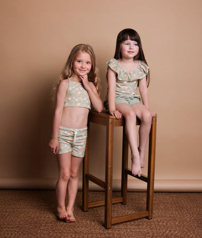 Girl wearing Evangelina sage swim top – side view with adjustable straps